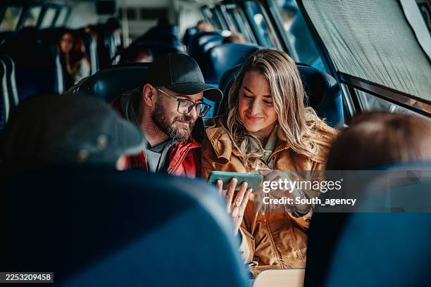 people using a phone on a berlin metro train while traveling during the day - train vehicle stock pictures, royalty-free photos & images