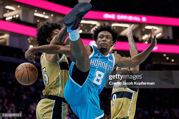 Collin Sexton of the Charlotte Hornets passes the ball around Marvin Bagley III of the Washington Wizards in the first half during their game at...