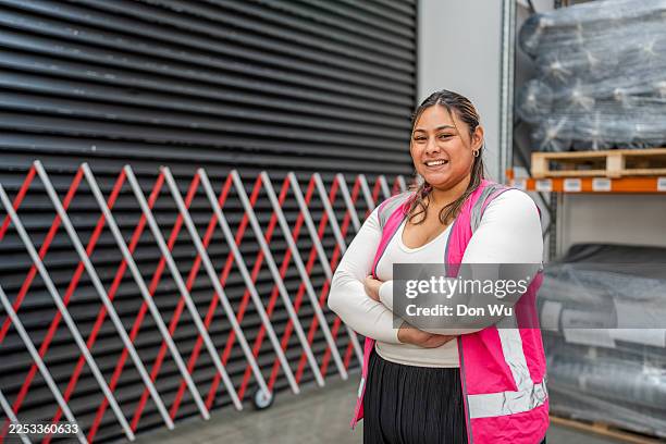 female warehouse worker standing with arms crossed - polynesian people stock pictures, royalty-free photos & images