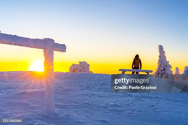 person watching colorful sunset in the snowy landscape - uitzichtpunt stockfoto's en -beelden