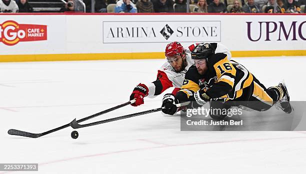 Justin Brazeau of the Pittsburgh Penguins scores a goal as K'Andre Miller of the Carolina Hurricanes defends in the first period at PPG PAINTS Arena...