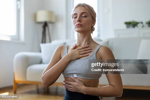 mujer practicando la respiración consciente y la atención plena en casa - técnica de imágenes fotografías e imágenes de stock