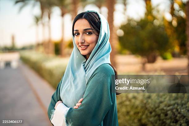 jeune femme arabe au soleil de riyad souriant avec confiance - voile religieux photos et images de collection