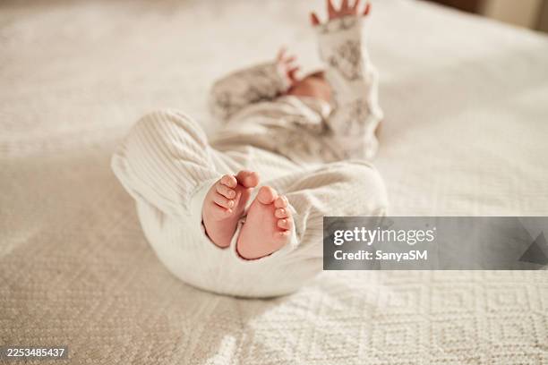 newborn baby feet stretching on white bed - toe stock pictures, royalty-free photos & images