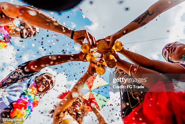 freunde stoßen während der karnevalsfeier auf der straße mit bier an - karneval feier stock-fotos und bilder