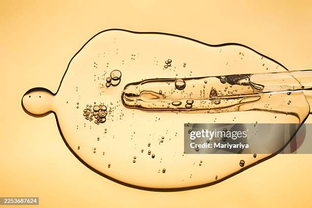 facial serum with peptides and spicules on golden background - retinol stock pictures, royalty-free photos & images