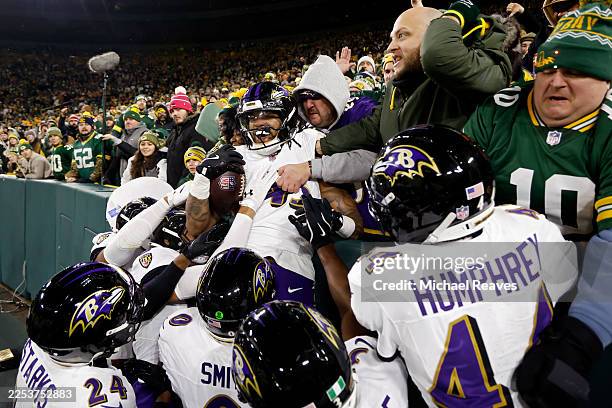 Mike Green of the Baltimore Ravens celebrates with teammates after recovering a fumble in the second quarter against the Green Bay Packers at Lambeau...