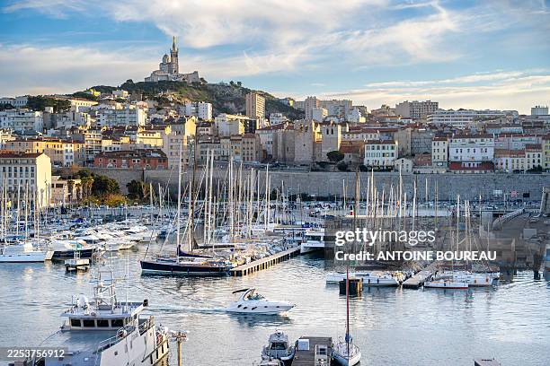 Overview of the Old Port and Notre Dame de la Garde with the Bonne Mere at its summit, symbol of the city of Marseille and the 7th arrondissement, on...