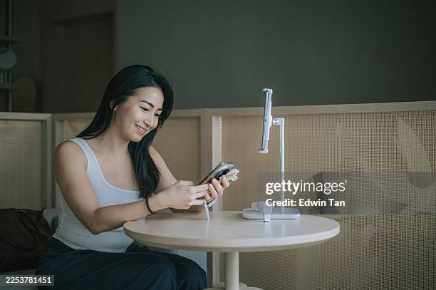femme asiatique heureuse qui examine les résultats d’analyses de soins de la peau sur smartphone lors d’une consultation au spa - résultats danalyses médicales photos et images de collection