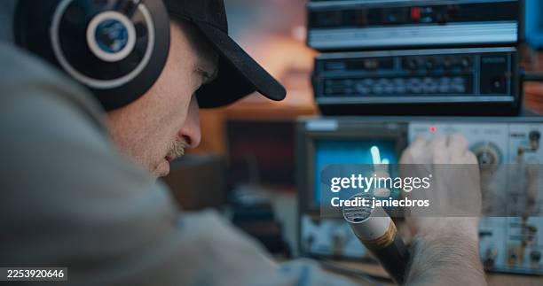 radio operator in large headphones adjusting the retro radio for communication. amateur radio station - difusão de televisão imagens e fotografias de stock