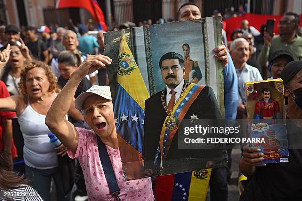Woman holds a portrait of Venezuelan President Nicolas Maduro during a gathering in Caracas on January 3 after US forces captured him. President...