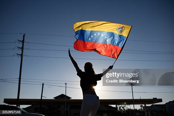 Demonstrator holds a Venezuelan flag during a rally in Katy, Texas, US, on Saturday, Jan. 3, 2026. President Nicolas Maduro has been charged in the...