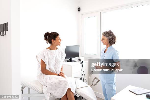 female gynecologist in consultation with patient preparing for a gynecological check-up - pap smear stock pictures, royalty-free photos & images