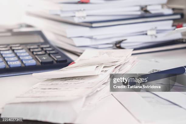 stack of receipts with calculator. lots of documents, papers and notepads on a desk. taxes - receipt mockup stock pictures, royalty-free photos & images