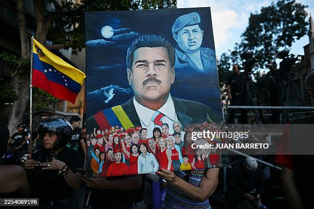 Woman shows a painting depicting ousted Venezuela's President Nicolas Maduro and former President Hugo Chavez during a demonstration by supporters in...