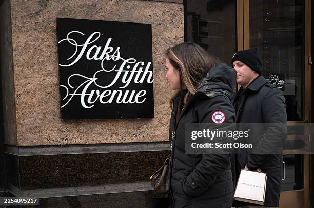 Pedestrians walk past a Saks Fifth Avenue store on December 30, 2025 in Chicago, Illinois. Recent reports indicate that Saks Global Enterprises, the...