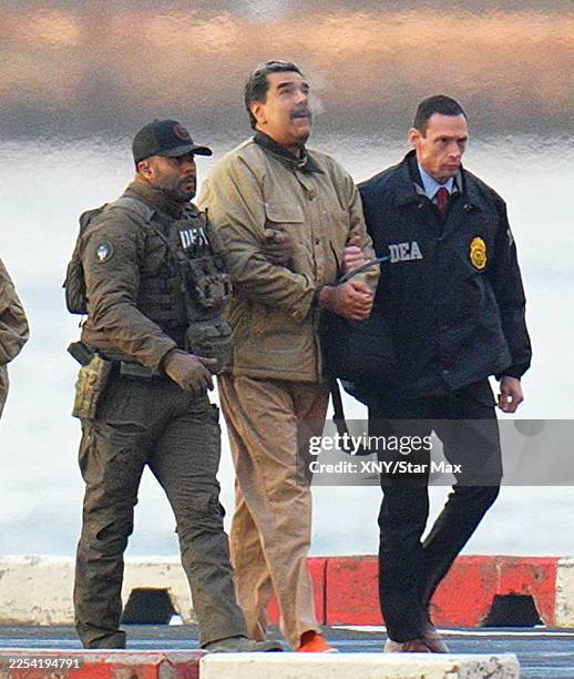 Nicolas Maduro is seen in handcuffs after landing at a Manhattan helipad, escorted by heavily armed Federal agents as they make their way into an...