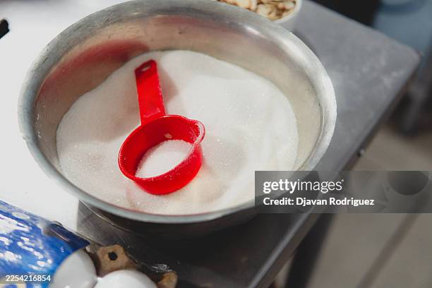white sugar in metal bowl with red measuring cup - sugar spoon stock pictures, royalty-free photos & images