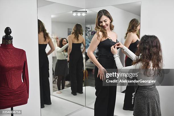 fashion designer measuring corset details in front of a mirror - celebrity stylist stock pictures, royalty-free photos & images