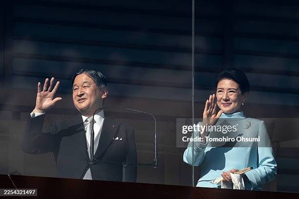 Japan's Emperor Naruhito and Empress Masako wave during the New Year's appearance by the Japanese imperial family at the Imperial Palace on January...