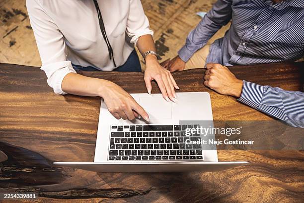 typing on laptop while working remotely in coffee shop - press release stock pictures, royalty-free photos & images