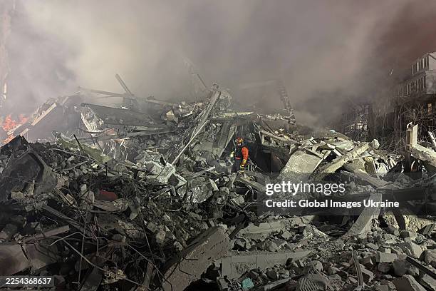 Rescue workers search for people under the rubble of a residential apartment building destroyed by a Russian missile strike on January 2, 2026 in...