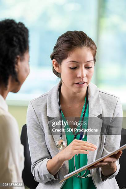 doctor explaining medical information to a patient during a consultation - medical test results stock pictures, royalty-free photos & images