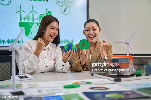 women discussing sustainable energy and recycling concepts happily - huella de carbono fotografías e imágenes de stock