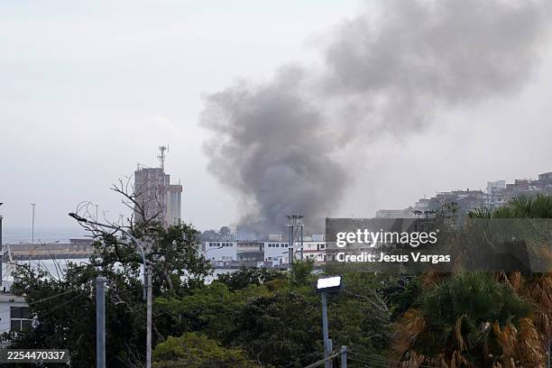 Smoke rises from Port of La Guaira after explosions and low-flying aircraft were heard on January 03, 2026 in La Guaira, Venezuela. According to some...