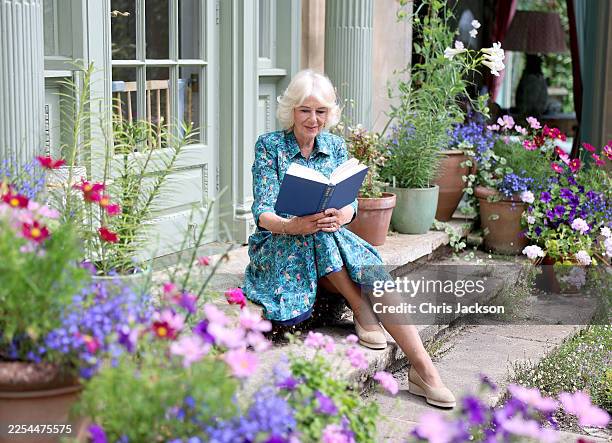 In this image released on January 8 Queen Camilla poses for a portrait in the garden of her home Ray Mill House in the village of Lacock in July...