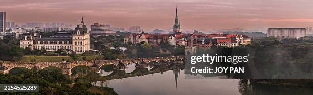 panoramic view of european-style buildings and stone bridge at huawei ox horn campus, china - dongguan stock pictures, royalty-free photos & images