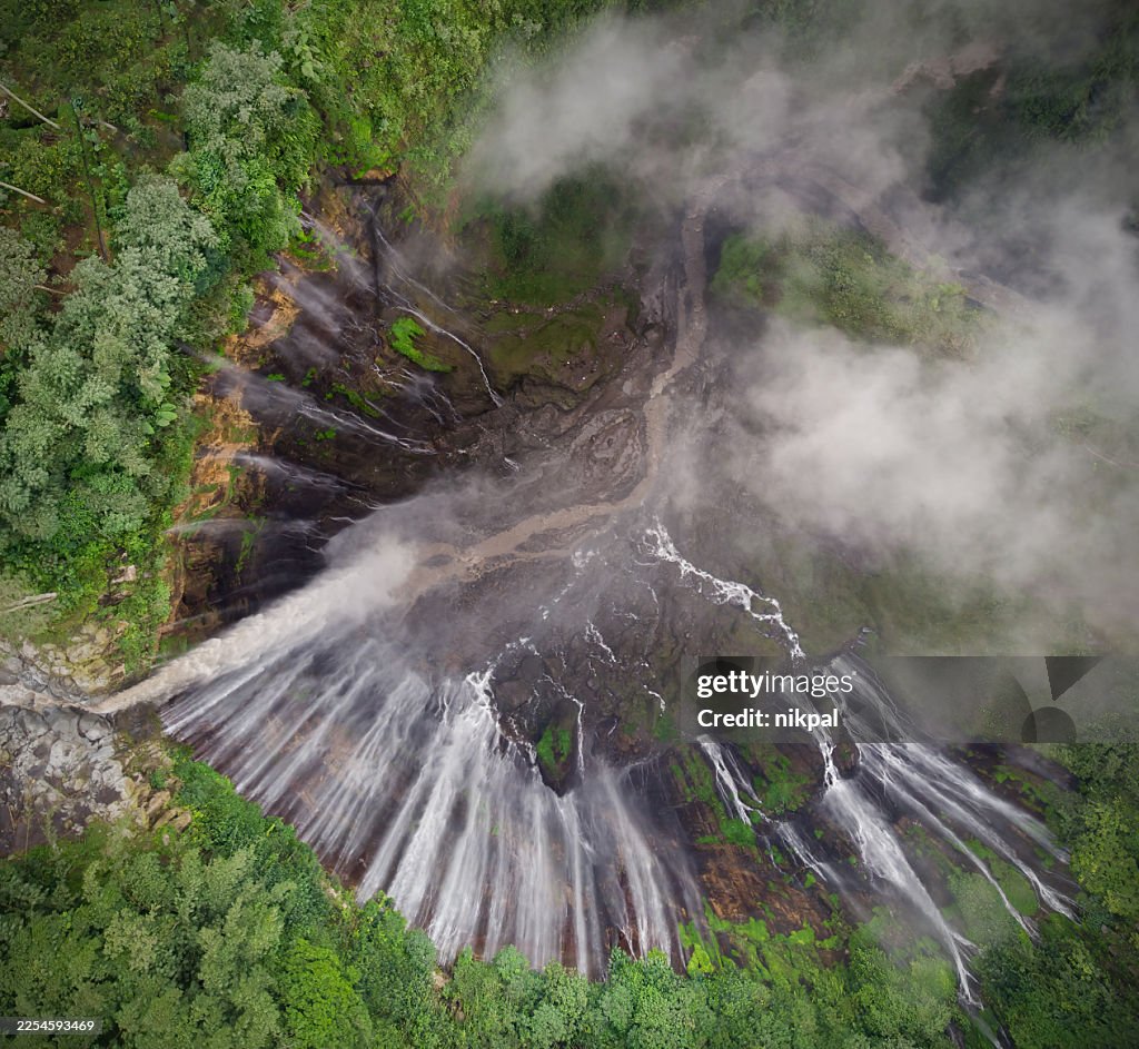 Tumpak Sewu from above with Mount Semeru on the background: the "waterfall of a thousand streams", Aerial view, East Java, Indonesia