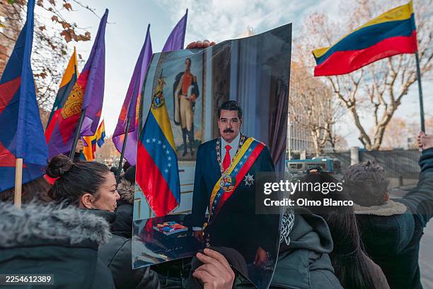 Protester holds the official Maduro's portrait during a protest against the capture of Nicolas Maduro in front of the US Embassy on January 4, 2026...