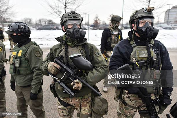 Federal agents stand guard as protestors gather outside the Bishop Henry Whipple Federal Building in Saint Paul, Minnesota, on January 8, 2026. A US...