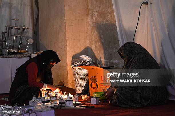 Afghan women make LED bulbs at a workshop in Herat on January 8, 2026.