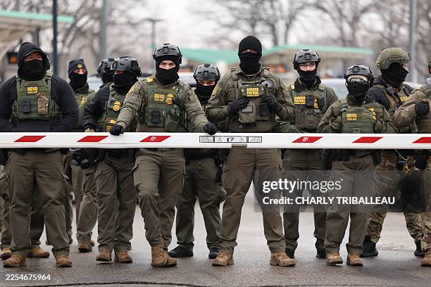Border Patrol agents stand guard at the Bishop Henry Whipple Federal Building in Minneapolis, Minnesota, on January 8, 2026. A US Immigration and...