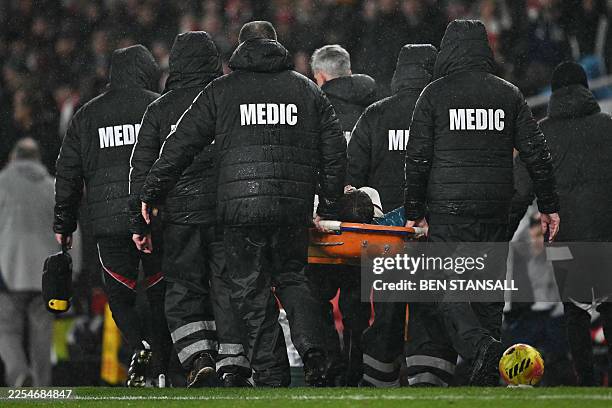 Liverpool's Northern Irish defender Conor Bradley is stretchered off the pitch injured during the English Premier League football match between...