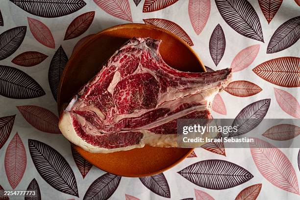 raw ribeye beef steak with marbling on ceramic plate ready for cooking - raw food stock pictures, royalty-free photos & images