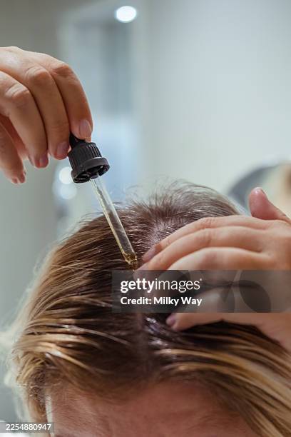 hair care routine with essential oil application for healthy scalp and hair growth - cuero cabelludo fotografías e imágenes de stock