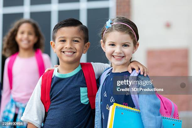 happy, diverse elementary school children with backpacks and notebooks ready for school. - first day of school stock pictures, royalty-free photos & images