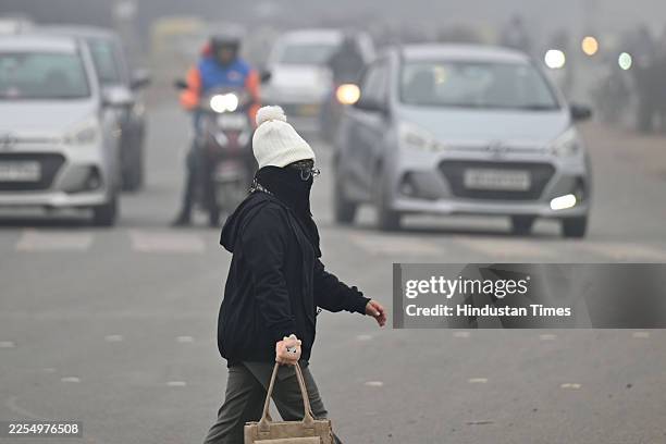 People are seen wearing warm clothes on a cold and foggy winter morning at Railway Road, as low temperatures continue to grip the city, on January...
