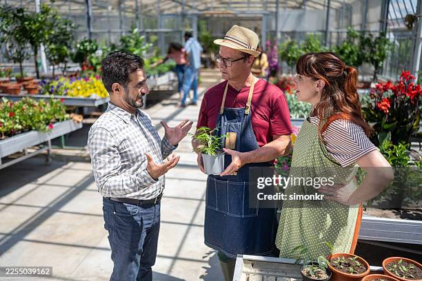 middle eastern customer engaging with caucasian garden experts - garden center stock pictures, royalty-free photos & images
