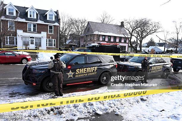 Members of the Hennepin County Sheriff's Office look on as people gather near the scene of a suspected shooting by an ICE agent during federal law...