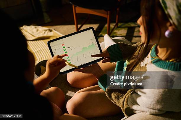 gen z young women analyzing stock market data on tablet - financial literacy stock pictures, royalty-free photos & images
