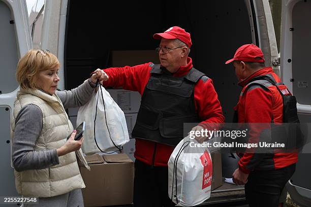 Woman receives humanitarian aid from the Ukrainian Red Cross Society after Russian shelling in Korabelnyi residential district on January 8, 2026 in...
