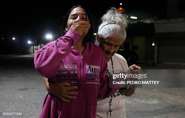 Lorealbert Gutierrez is comforted while waiting for news on the release of prisoners, outside El Rodeo I prison in Guatire, Miranda State, some 30...