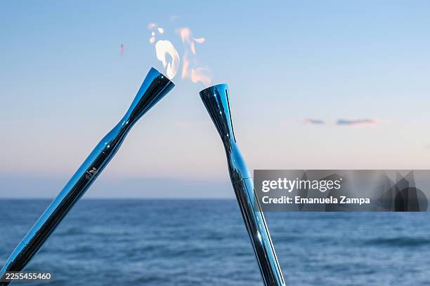 The Olympic fire of Milano Cortina 2026 passes from torch to torch during the Olympic Torch Relay on January 09, 2026 in Genoa, Italy.