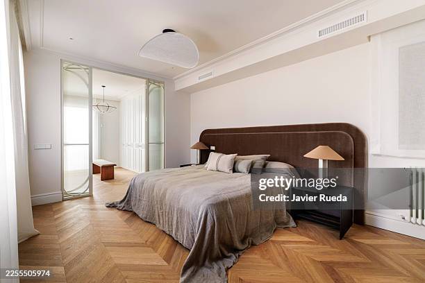 wide bedroom with open glass wardrobe doors - parket stockfoto's en -beelden