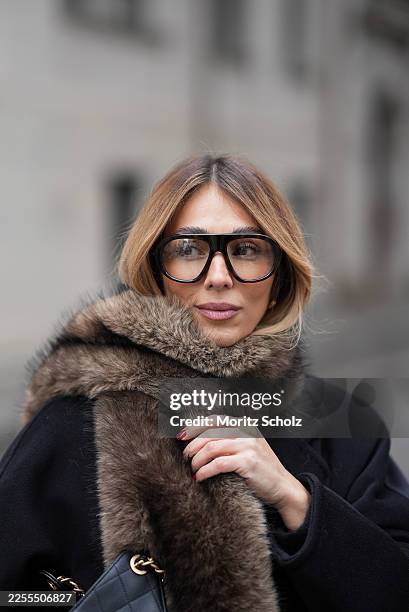 Oeznur Sinani alias Sinperi is seen wearing a long black wool coat from Max Mara; a black quilted grained calfskin leather Chanel 25 medium handbag...