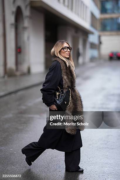 Oeznur Sinani alias Sinperi is seen wearing a long black wool coat from Max Mara; wide-leg black tailored trousers with relaxed fit from COS; black...